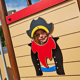 Boy on a pirate themed multi play structure